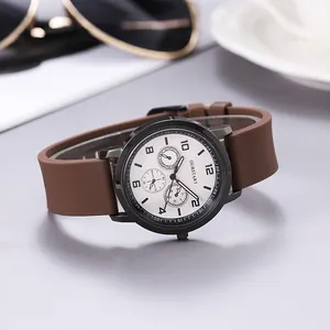 Quartz watch with brown silicone strap and black matte case shown with accessories