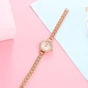 Close-up of rose gold watch with crystal bezel and mother of pearl textured dial