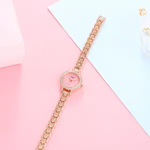 Close-up of rose gold watch with pink dial and sparkling rhinestones on jewelry box