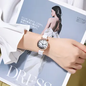 Detail of minimalist women's watch with gradient dial and white strap on a wrist