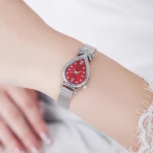 Teardrop watch with red dial, rhinestone bezel, and silver mesh strap worn by a model
