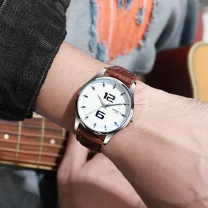 Nahaufnahme einer minimalistischen Quarzuhr mit braunem Lederarmband am Handgelenk
