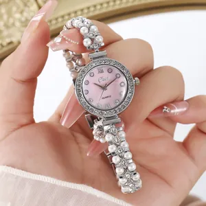 Vue macro d'une montre femme avec cadran nacré rose et bracelet à doubles perles
