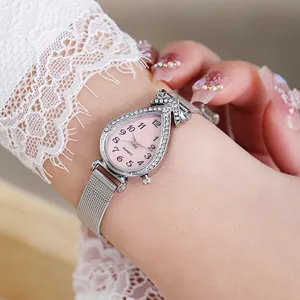 Detail of teardrop quartz watch with pink dial and silver mesh band on woman wrist
