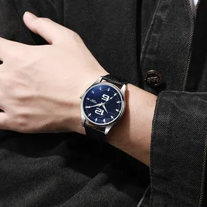 Nahaufnahme einer Herren-Quarzuhr mit blauem Zifferblatt und schwarzem Lederarmband