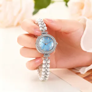 Détail d'une montre femme élégante avec cadran nacré bleu et bracelet en perles perlées