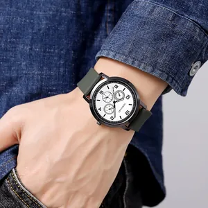 Close-up of a minimalist white dial quartz watch with green silicone strap on a wrist