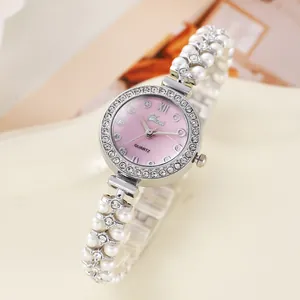 Détail du cadran en nacre rose avec lunette en cristal et bracelet de perles