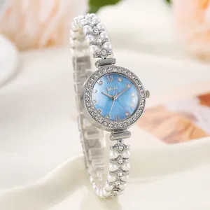 Détail de montre pour femme avec cadran nacré bleu et bracelet en perles élégant