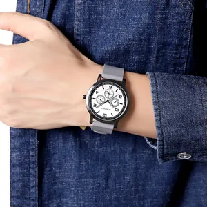 Close-up of men's casual quartz watch with white dial and grey silicone strap on wrist