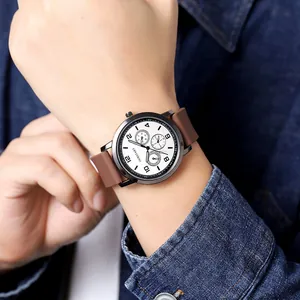 Close-up of men's minimalist watch with white dial, black markers and brown strap
