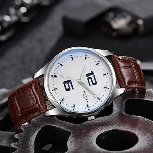 Details einer Quarzuhr mit blauen Indizes auf weißem Zifferblatt und Lederarmband