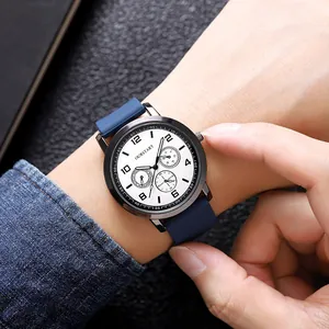 Close-up of a blue silicone strap quartz watch with a black case on a male wrist