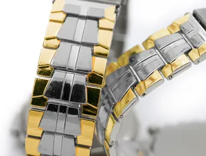 Vue macro d'un bracelet de montre bicolore en acier inoxydable à maillons dorés