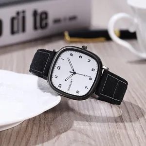 Macro view of square quartz watch with white brushed dial and black suede strap