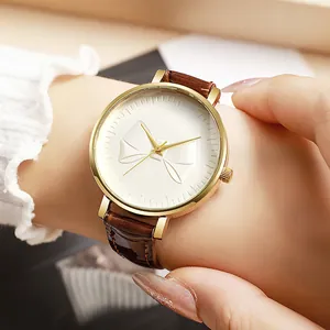 Elegant ladies quartz watch with 3D bow relief dial and brown leather strap on wrist