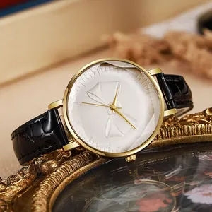 Detailed macro shot of a golden bow-tie relief on a white dial women quartz watch
