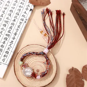 Close-up of ethnic handmade woven watch with rhinestone bezel and colorful beaded tassels