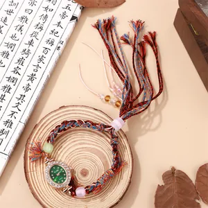 Ethnic style quartz watch with green oval dial, woven colorful strap and tassel detail