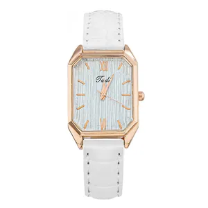 Detalle de reloj rectangular vintage en oro rosa con correa de cuero blanco de cocodrilo
