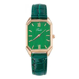 Detalle de reloj rectangular de oro rosa con esfera verde y correa de cuero elegante