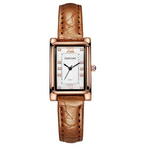 Detail of square rose gold watch with brown leather strap and crystal hour markers