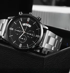 Macro shot of silver steel chronograph watch with black dial and three sub-dials in a box
