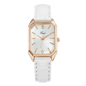 Primer plano de reloj octogonal Tadi con caja de oro rosa y correa de cuero blanca