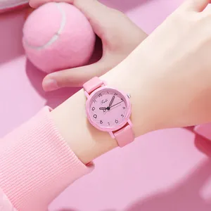 Gros plan d'une montre à quartz rose avec bracelet en cuir et chiffres clairs