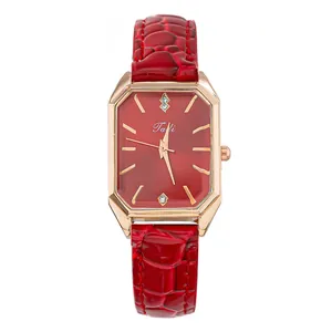 Primer plano de un reloj vintage rectangular con esfera roja y correa de cuero
