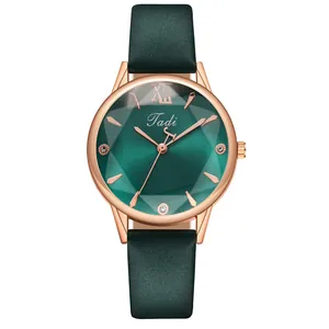 Detailed macro of green faceted glass dial and rose gold case of a lady's watch