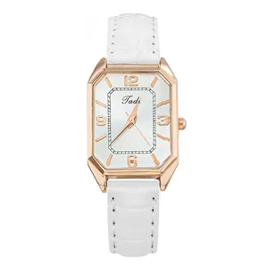 Detalle de reloj octogonal en oro rosa con correa de cuero blanco con textura de cocodrilo