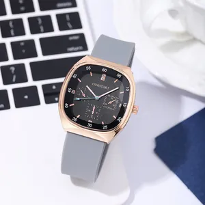 Detailopname van een roségouden tonneau kwartshorloge met grijze siliconen band