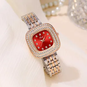 Detail of a ladies' square watch with deep red dial, diamond bezel, and two-tone steel strap