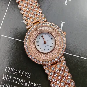 Dettaglio orologio da donna in oro rosa con strass scintillanti e cinturino lucido