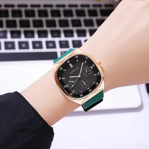 Detailopname van een vierkant roségoud quartzhorloge met zwarte wijzerplaat en groene band