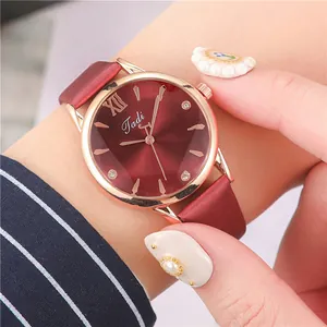 Macro shot of Tadi women's watch featuring a deep red sunburst dial and rhinestone markers