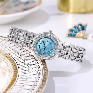 Detail of silver women's watch with rhinestone bezel and blue sunray dial on ceramic tray