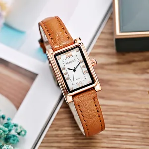 Macro view of a square rose gold ladies watch with crystal indexes and brown leather strap
