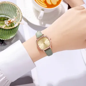 Close-up of a women's vintage square watch with sage green leather strap on wrist