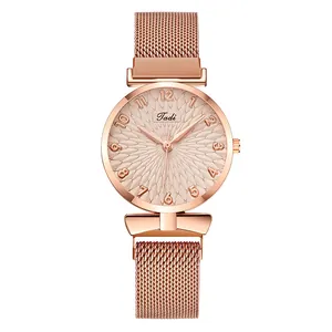 Vue macro du cadran or rose avec texture pétale et bracelet en maille milanaise