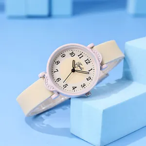 Close-up of pink quartz watch for girls with cream silicone strap on blue background