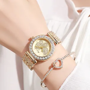 Detail shot of a women's gold watch and heart bracelet set with butterfly rhinestones