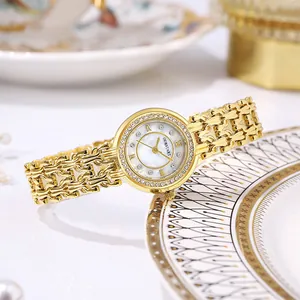 Detailed close-up of a women's gold-plated watch with mother-of-pearl dial and crystals