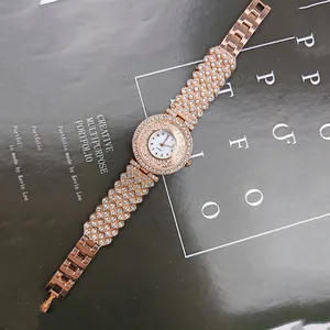 Dettaglio macro dell'orologio al quarzo oro rosa con strass su sfondo scuro di rivista