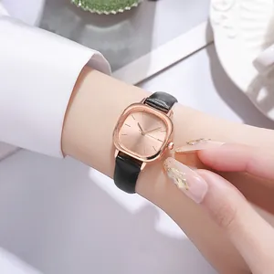 Close-up of elegant rose gold square watch with black leather strap on a wrist