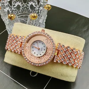 Dettaglio dell'orologio al quarzo oro rosa con strass su un cuscino di velluto beige