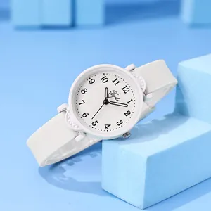 Macro view of minimalist white quartz watch with black numerals and silicone strap