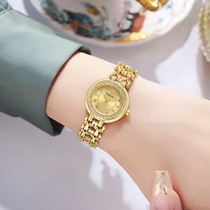 Close-up of elegant gold women's watch with rhinestone bezel and chain bracelet band