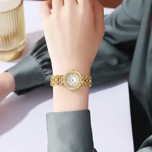 Close-up of elegant gold women's watch with mother of pearl dial and rhinestone bezel